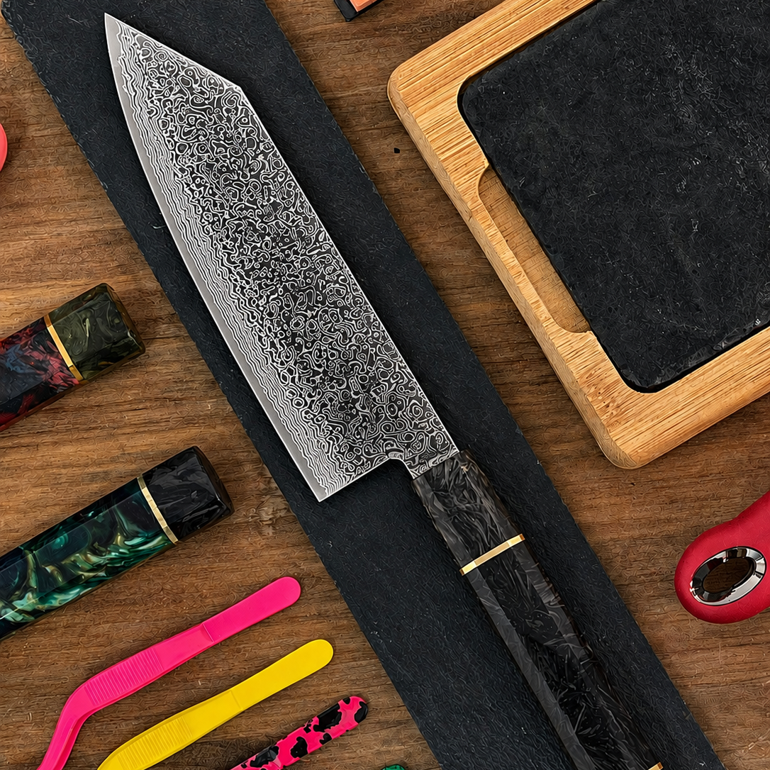 Cuchillo Bunka Damascus VG10 con mango de fibra de carbono sobre tabla de madera, rodeado de accesorios de cocina coloridos