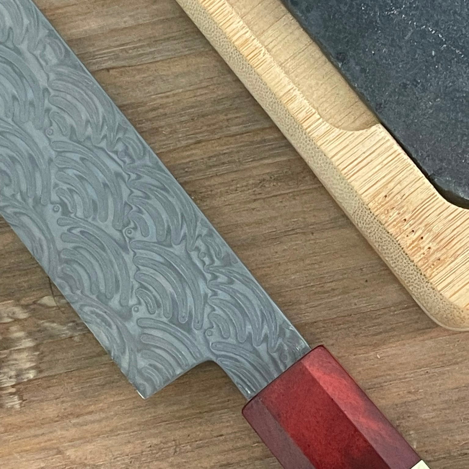 Primer plano patrón damasco 110 capas hoja cuchillo sashimi con mango madera roja