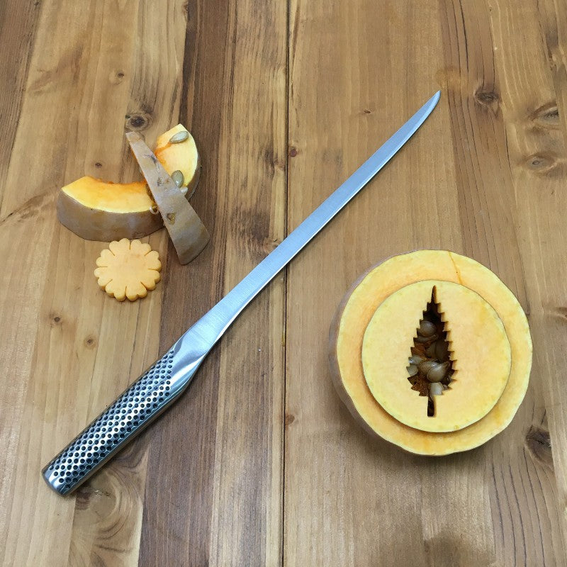 Cuchillo Global G-95 jamonero sobre superficie de madera, perfil de hoja flexible larga