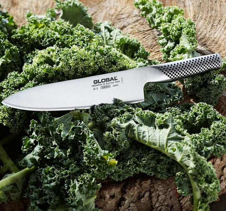 Cuchillo chef Global G-2 Serie G sobre tabla de corte de madera